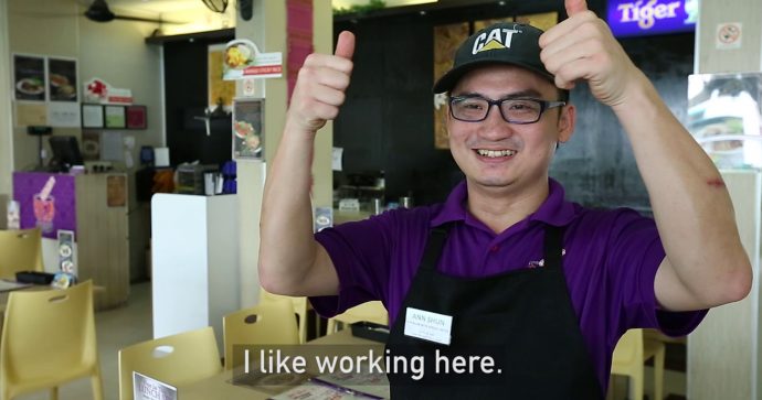 A restaurant employee smiling and giving a thumbs up