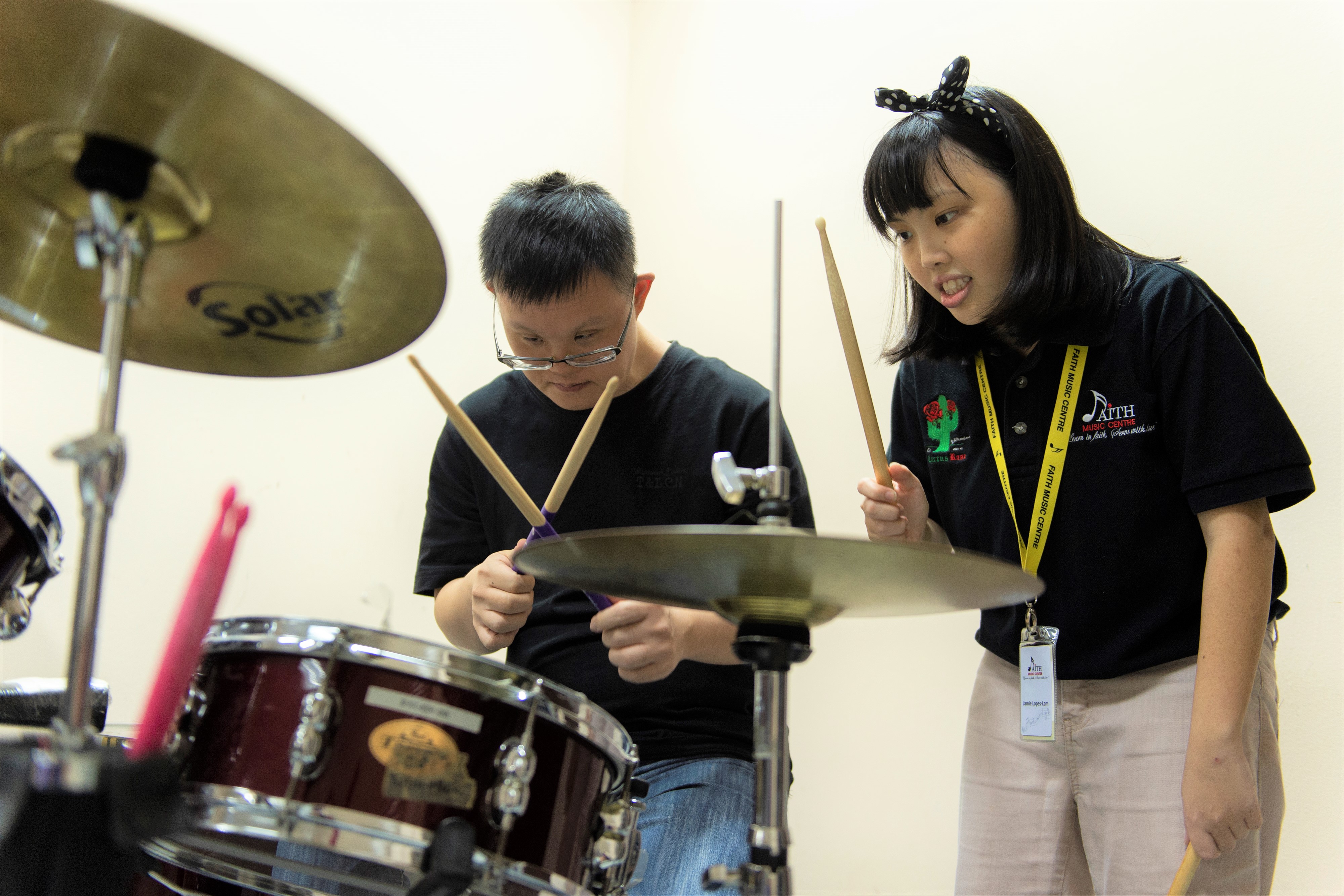 Two youth with special needs playing the drums at Faith Music Centre