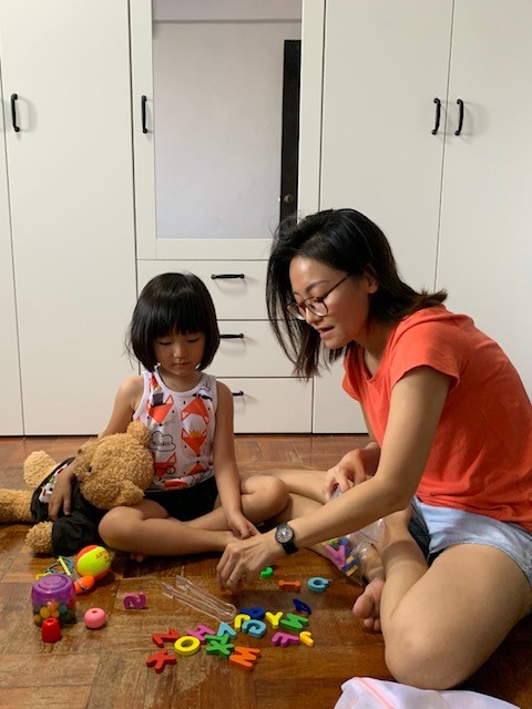 Wen Jing spending time with her daughter at home, playing with some alphabet blocks.