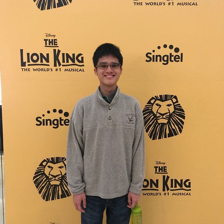 The photo shows Wesley against the backdrop of a Musical “The Lion King”