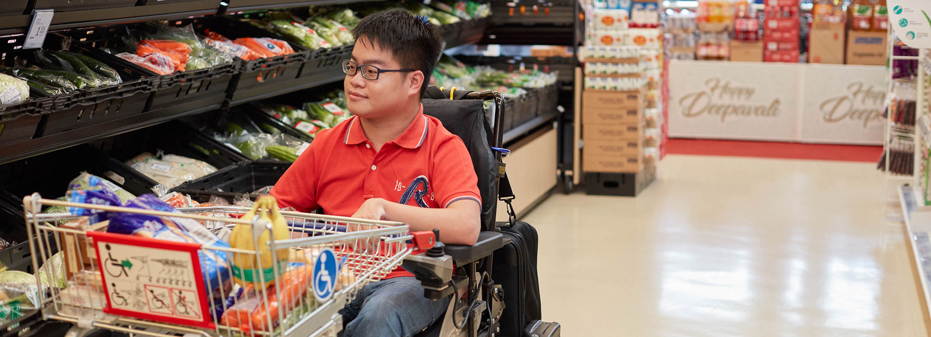 Young man in motorized wheelchair shopping for groceries in the supermarket
